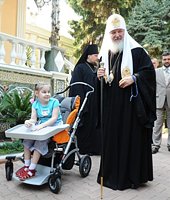Святейший Патриарх Кирилл благословил девочку, страдающую детским церебральным параличом, и подарил ей специальную коляску для детей с ограниченными возможностями